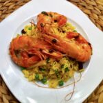 Krewetki smażone w czterech smakach po tajsku podane z kolorowym ryżem z warzywami.