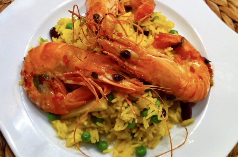 Krewetki smażone w czterech smakach po tajsku podane z kolorowym ryżem z warzywami.