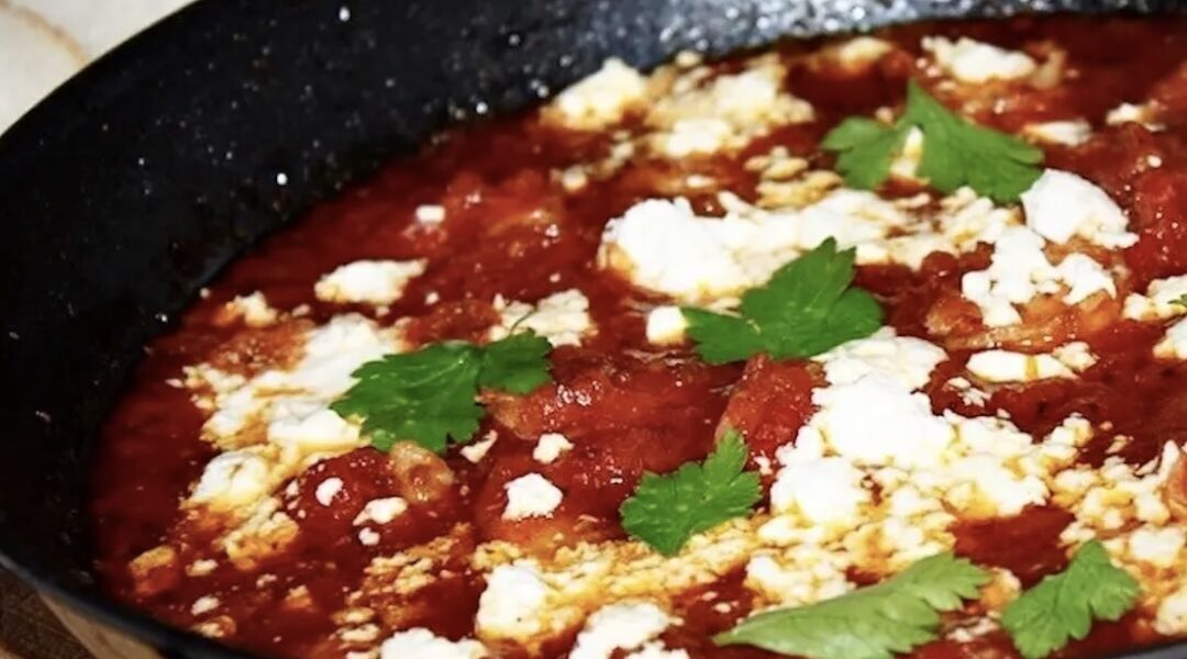 Krewetki smażone w patelni saganaki, a następnie duszone w pomidorach na koniec posypane serem feta i zapiekane.