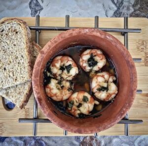 Krewetki smażone z czosnkiem w sporej ilości oliwy na koniec posypane natką pietruszki i podawane z pieczywem.