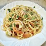 Krewetki smażone na oliwie z dodatkiem soku z cytryny, czosnku i natki pietruszki podane z makaronem spaghetti.