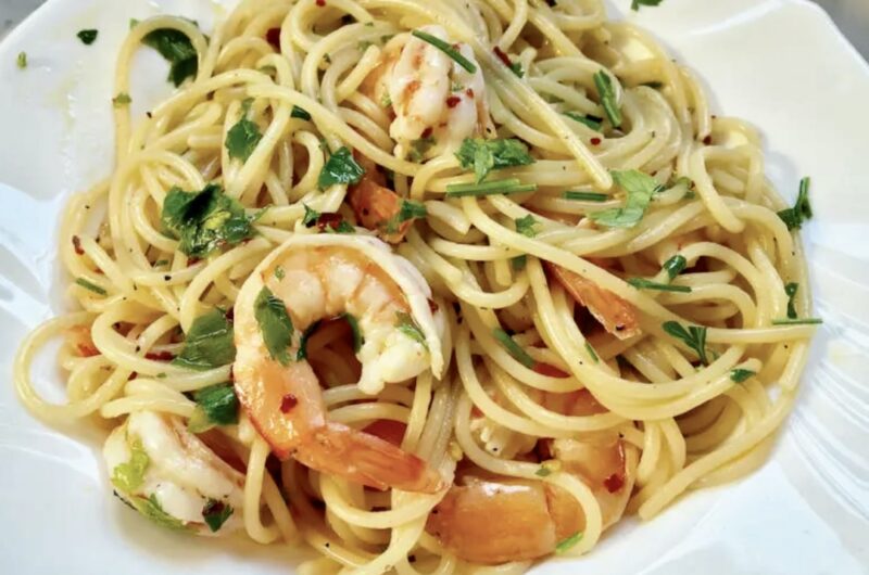 Krewetki smażone na oliwie z dodatkiem soku z cytryny, czosnku i natki pietruszki podane z makaronem spaghetti.