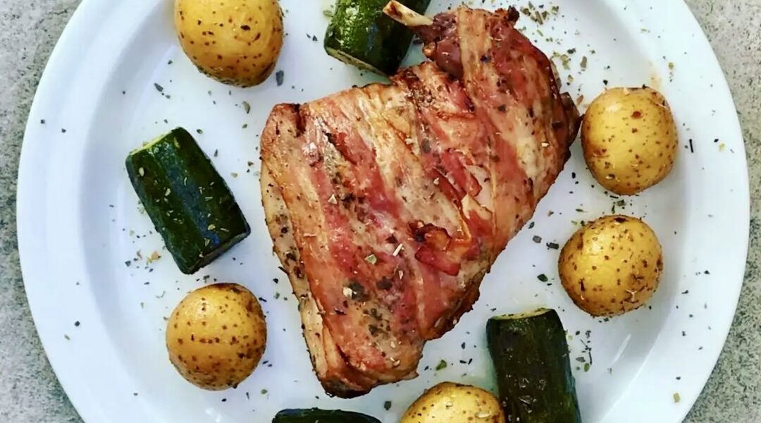 Królik, a konkretnie jego udka, owinięty plasterkami boczku i pieczony razem z warzywami.