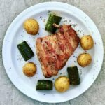 Królik, a konkretnie jego udka, owinięty plasterkami boczku i pieczony razem z warzywami.