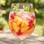 Kruszon brzoskwiniowy czyli napój alkoholowy przygotowany z wina musującego, miodu i dojrzałych owoców z dodatkiem wielu kostek lodu.