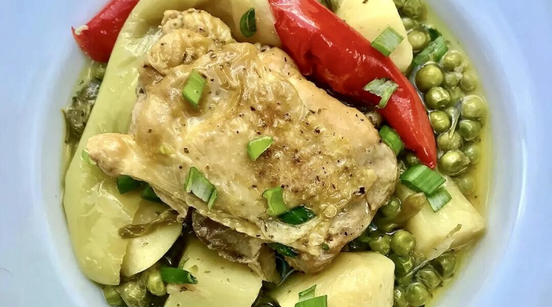 Kura podzielona na kawałki i duszona z ziemniakami i zielonym groszkiem wraz z dodatkiem dymki i rozmarynu.