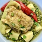 Kura podzielona na kawałki i duszona z ziemniakami i zielonym groszkiem wraz z dodatkiem dymki i rozmarynu.