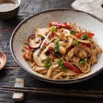 Kurczak chow mein czyli makaron z dodatkiem krojonych piersi z kurczaka krótko smażonych razem z papryką, pieczarkami, imbirem oraz kiełkami fasoli.