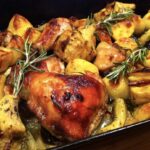 Kurczak w kawałkach pieczony razem z ziemniakami, czosnkiem i karczochami z dodatkiem świeżego rozmarynu.
