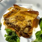 Lazania czyli płaty makaronu przekładane mięsem mielonym duszonym w pomidorach z suszonymi przyprawami, a następnie zapiekana z serem w środku i na wierzchu.