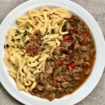 Gulasz na bazie mięsa pozostałego z obiadu z dnia poprzedniego przygotowany na winie z dodatkiem cebuli, pieczarek i świeżej papryki doprawiony mieloną papryką.