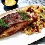 Łosoś marynowany w sosie sojowym, imbirze i chili, a następnie pieczony i podany z sałatką z bulgurem i fenkułem.