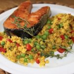 Świeży łosoś marynowany w świeżych ziołach podany z grilla razem z bulgurem i warzywami.