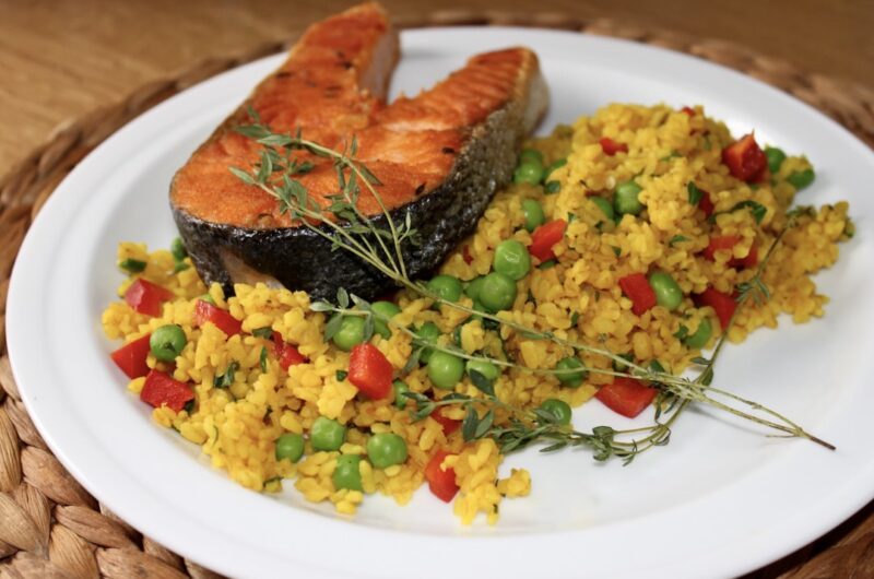Świeży łosoś marynowany w świeżych ziołach podany z grilla razem z bulgurem i warzywami.