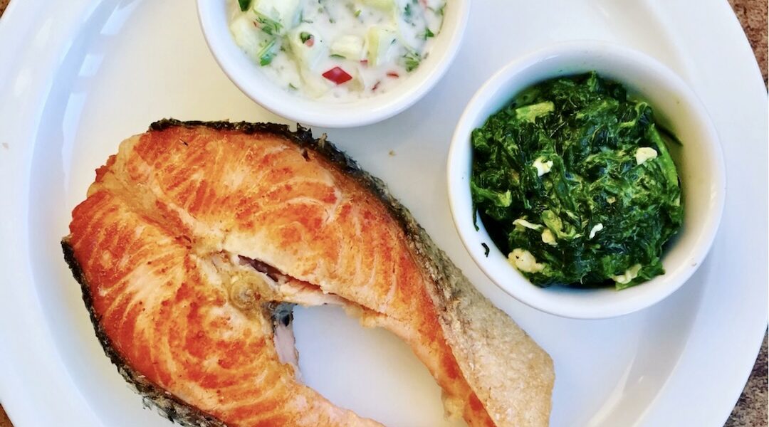 Łosoś w postaci dzwonka smażony krótko na dość mocnym ogniu podany ze szpinakiem na gęsto przyrządzonym z dodatkiem sera brie.