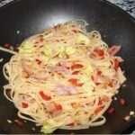 Makaron zmieszany z gotowaną golonką krótko przesmażoną z drobno krojonymi warzywami.