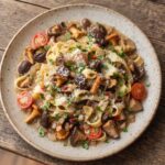 Makaron z różnorakimi świeżymi grzybami leśnymi podsmażanymi z chilli, cebulą i czosnkiem wzbogacony o pomidorki koktajlowe.