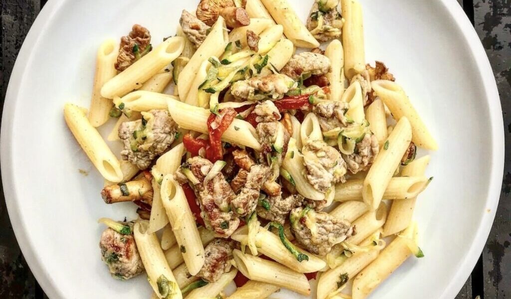 Makaron przygotowany z pachnącymi lasem kurkami z dodatkiem smażonej polędwiczki wieprzowej, startej cukinii, papryki i dymki.