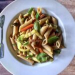 Makaron z pokrojoną w paski mortadelą podany ze smażonymi na oliwie papryką oraz groszkiem.