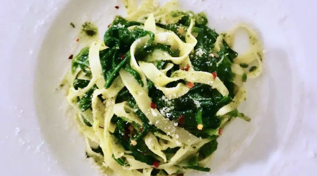 Makaron podany z sosem pesto przygotowanym z sera owczego i oliwy ze świeżą rukolą.