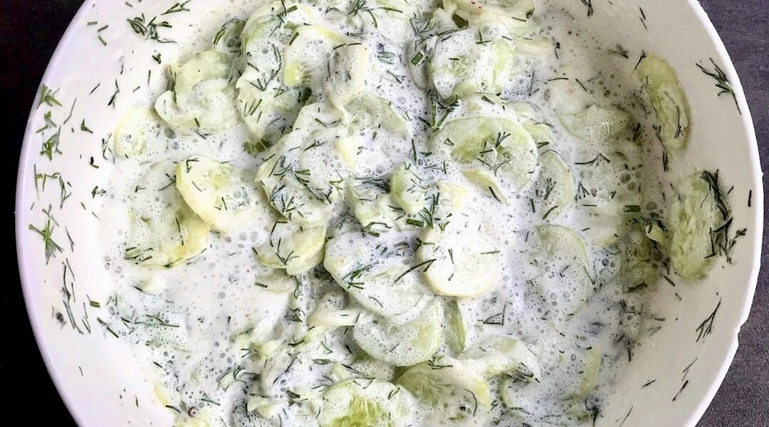 mizeria czyli krojone w cienkie plasterki świeży ogórek podany z kwaśną śmietaną i świeżym koperkiem