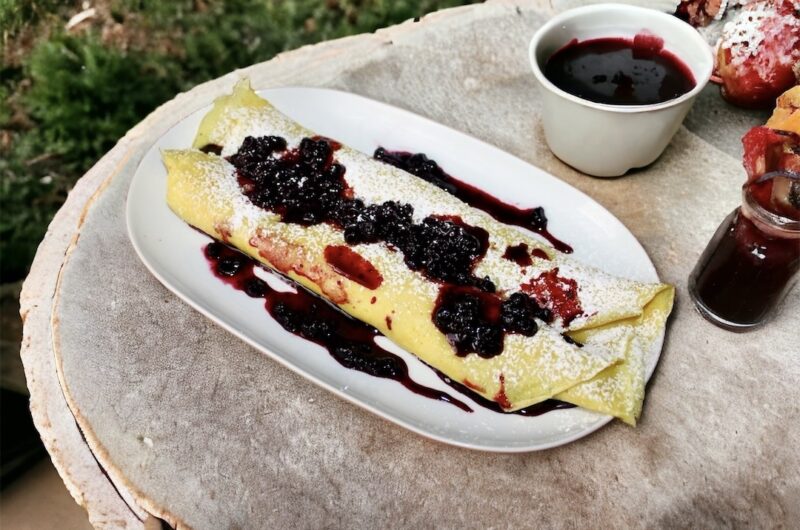 Naleśniki posmarowane dżemem z kawałkami owoców, następnie zwinięte w rulon i podane z owocami leśnymi.
