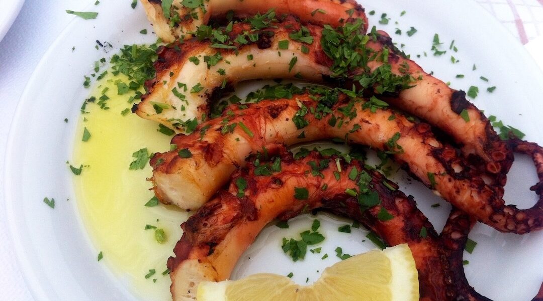 Idealnie przygotowana ośmiornica z grilla podana z greckim puree z grochu.