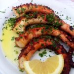 Idealnie przygotowana ośmiornica z grilla podana z greckim puree z grochu.