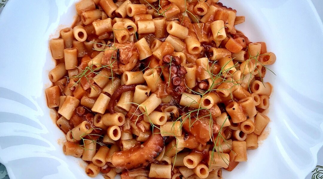 Ośmiornica gotowana, a następnie duszona z drobno krojonymi warzywami w sosie pomidorowym, na koniec połączona z makaronem.