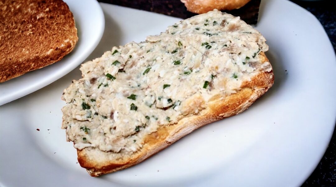 Pyszna pasta rybna do pieczywa przygotowana z wędzonej ryby z dodatkiem startych gotowanych jajek, kwaśnej śmietany i siekanego szczypiorku.