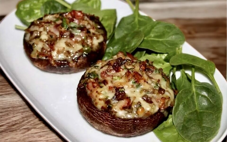 Pieczarki faszerowane szynką szwarcwaldzką, serem, cebulą i dymką, a następnie zapieczone.