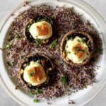 Pieczarki zapiekane z żółtym serem wypełnione są kawałkami twardego sera z dodatkiem chilli, musztardy, skórki z limonki, czosnku i dymki, a następnie zapiekane.