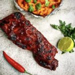 Marynowane przez noc w przyprawach żeberka wieprzowe pieczone długo w niskiej temperaturze podane z sosem BBQ.