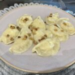 pierogi ruskie z twarogiem i ziemniakami na dużym talerzu