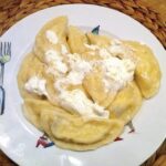 Pierogi z serem na słodko, czyli pierogi  wypełnione twarogiem zmieszanym z kwaśną śmietaną z dodatkiem rodzynek, wanilii i soku pomarańczowego.