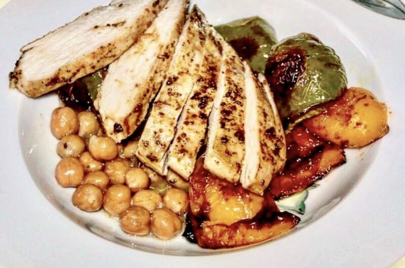 Pierś kurczaka pieczona z warzywami pokrojonymi na kawałki podana z ciecierzycą w sosie z tymiankiem i cytryną.