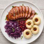 Pierś z kaczki krótko smażona, a następnie pieczona i podana w sosie własnym z dodatkiem kremu balsamicznego i z żurawiną.