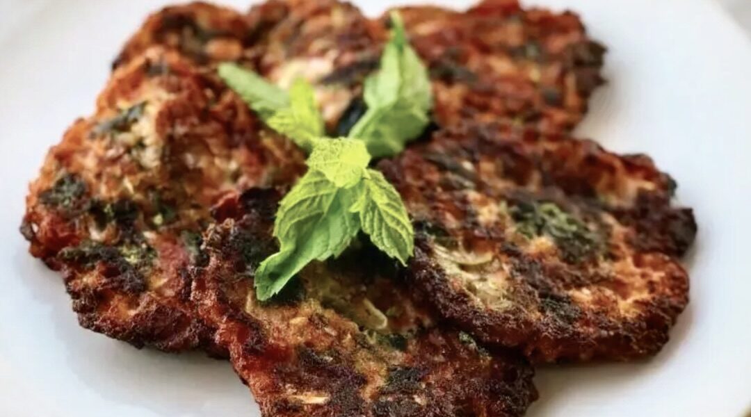 Placki przygotowane ze startych pomidorów Lima z dodatkiem startej cukinii, sera, świeżych ziół i mąki, smażone na patelni tuż przed ich podaniem.