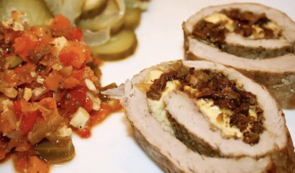 Cała polędwiczka wieprzowa przekrojona wzdłuż na połowę, rozbita na duży płat mięsa, a następnie faszerowana grzybami i serem, zawinięta i zapieczona.