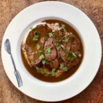 Policzki wołowe duszone w czerwonym winie z dodatkiem warzyw i rozmarynu.