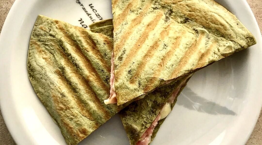 Quesadilla z mortadelą to tortilla obłożona serem camembert, włoską mortadelą i świeżą rukolą, a następnie przykrytą drugą tortillą i podgrzana.