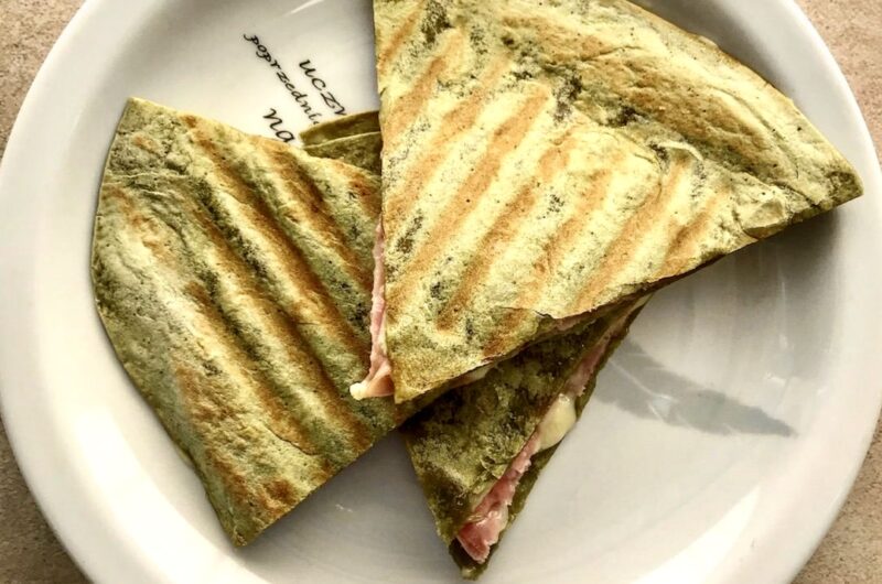 Quesadilla z mortadelą to tortilla obłożona serem camembert, włoską mortadelą i świeżą rukolą, a następnie przykrytą drugą tortillą i podgrzana.