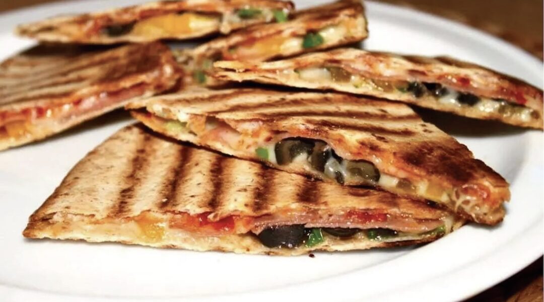 Quesadilla z salami czyli tortilla z serem i z ostrym salami, oliwkami i papryką, skropiona ostrym sosem, przykryta drugą tortillą i podgrzana na patelni.