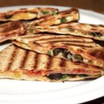 Quesadilla z salami czyli tortilla z serem i z ostrym salami, oliwkami i papryką, skropiona ostrym sosem, przykryta drugą tortillą i podgrzana na patelni.