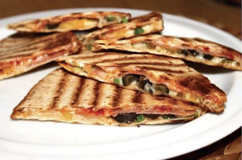 Quesadilla z salami czyli tortilla z serem i z ostrym salami, oliwkami i papryką, skropiona ostrym sosem, przykryta drugą tortillą i podgrzana na patelni.