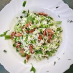 Gotowany ryż wymieszany z groszkiem i przesmażoną kiełbasą z dodatkiem wielu świeżych ziół.