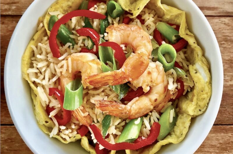 Ugotowany, a następnie krótko smażony ryż z krewetkami, dymką, papryką oraz omletem z jajka doprawiony sosem sezamowym.