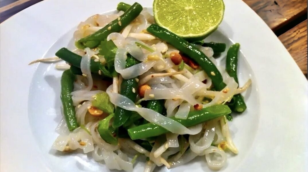 Sałatka azjatycka powstała z połączenia makaronu ryżowego z fasolką szparagową, kolendrą, orzeszkami i ziarnami sezamu. Całość polana została olejem z prażonego sezamu.