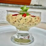 Sałatka krewetkowa z dodatkiem kaparów, papryki, suszonych śliwek podana z jogurtem i kolendrą.