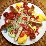 Smakowita sałatka z chrupiącym smażonym kurczakiem, podana z warzywami i polentą oraz z dressingiem o smaku bazylii.